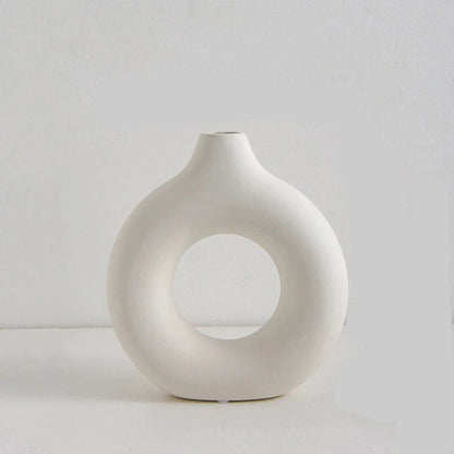 White ceramic vase with circular design on a light gray background, showing measurements.