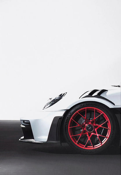 Close-up of a white sports car with red wheels on a light gray background