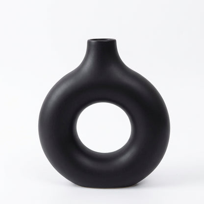 Black vase with circular design on a light gray background, showing measurements.